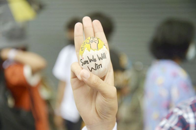 A pro-democracy protester raises a decorated Easter egg along with the three-fingered symbol of resistance during a protest against the military coup on Easter Sunday, April 4 in Yangon, Myanmar. (AP Photo)